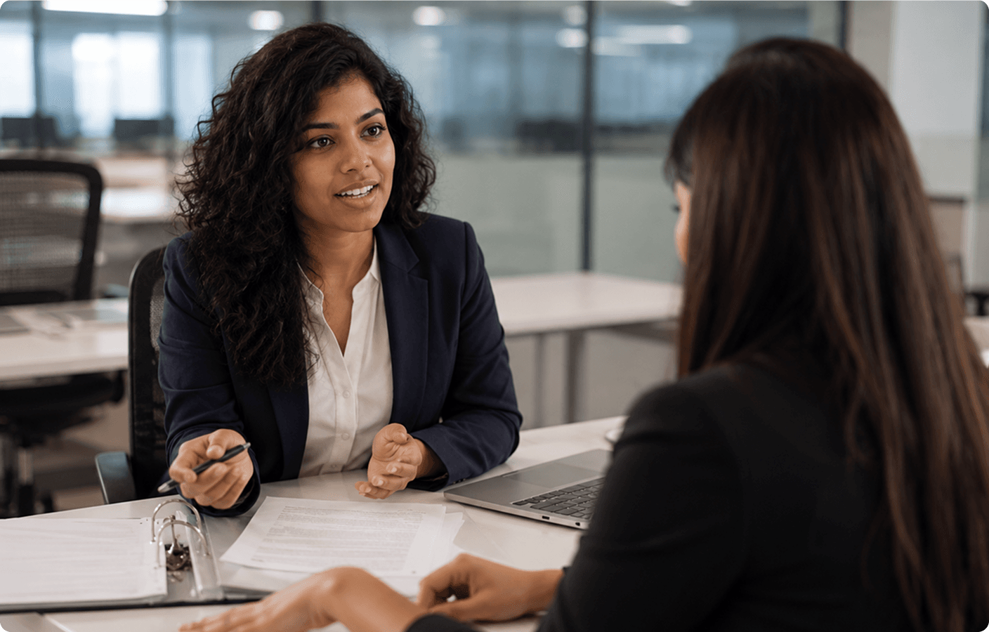 Banking professionals discussing workforce policies and documents at a branch office desk