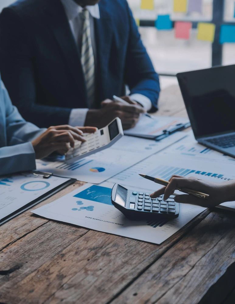 Financial professionals reviewing reports and calculations at a desk