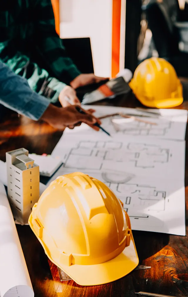 Construction professionals reviewing architectural blueprints on site