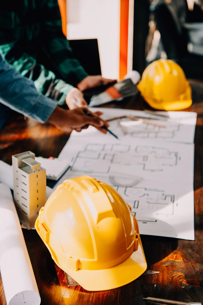 Construction professionals reviewing architectural blueprints on site