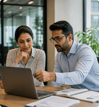 Finance professionals reviewing payroll-linked reports on a laptop