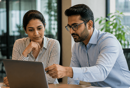 Finance professionals reviewing payroll-linked reports on a laptop