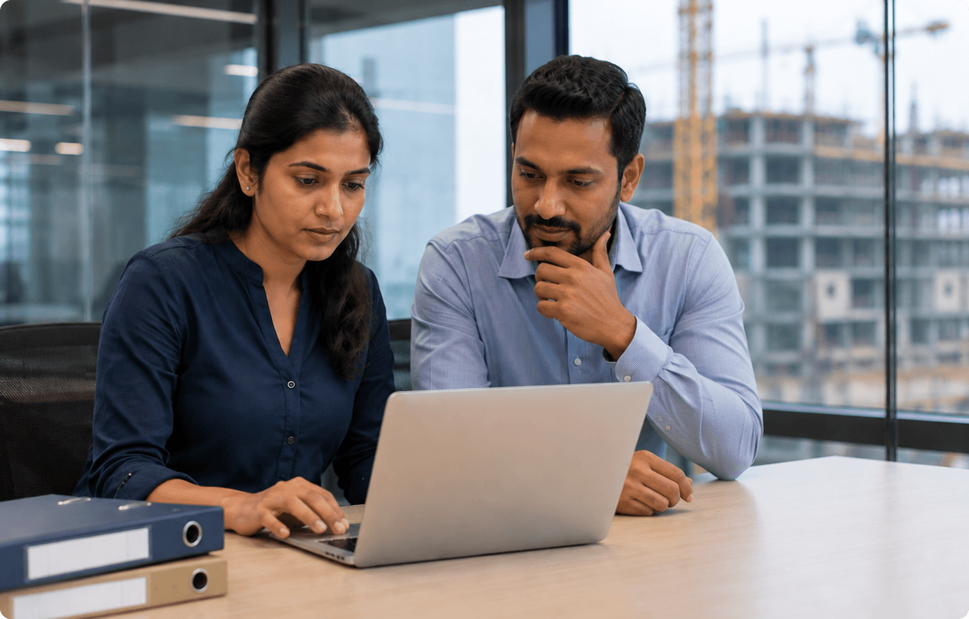 HR and finance professionals reviewing payroll data together on a laptop in an office