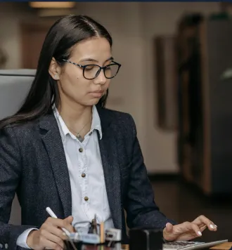 Receptionist with glasses working at a front desk in a modern office