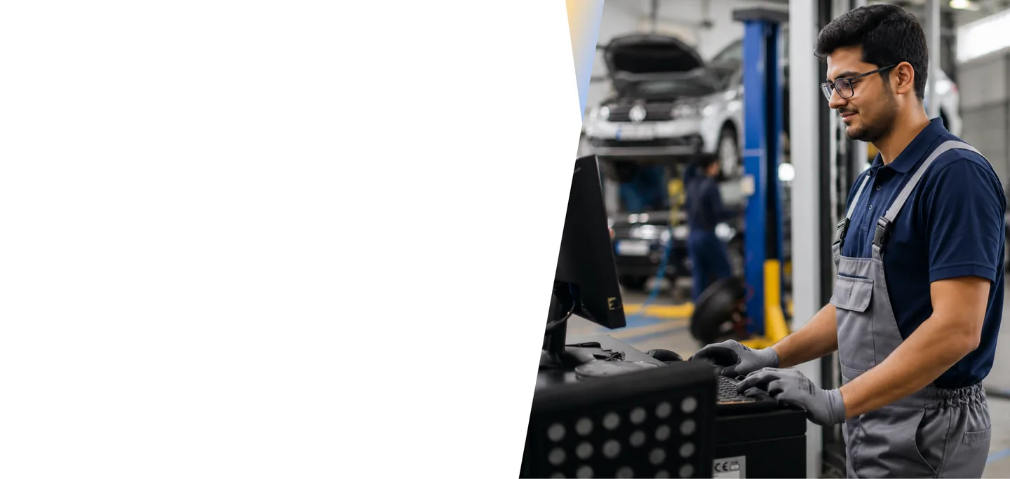 Automotive workshop technician reviewing workforce data on a monitor in a car service center