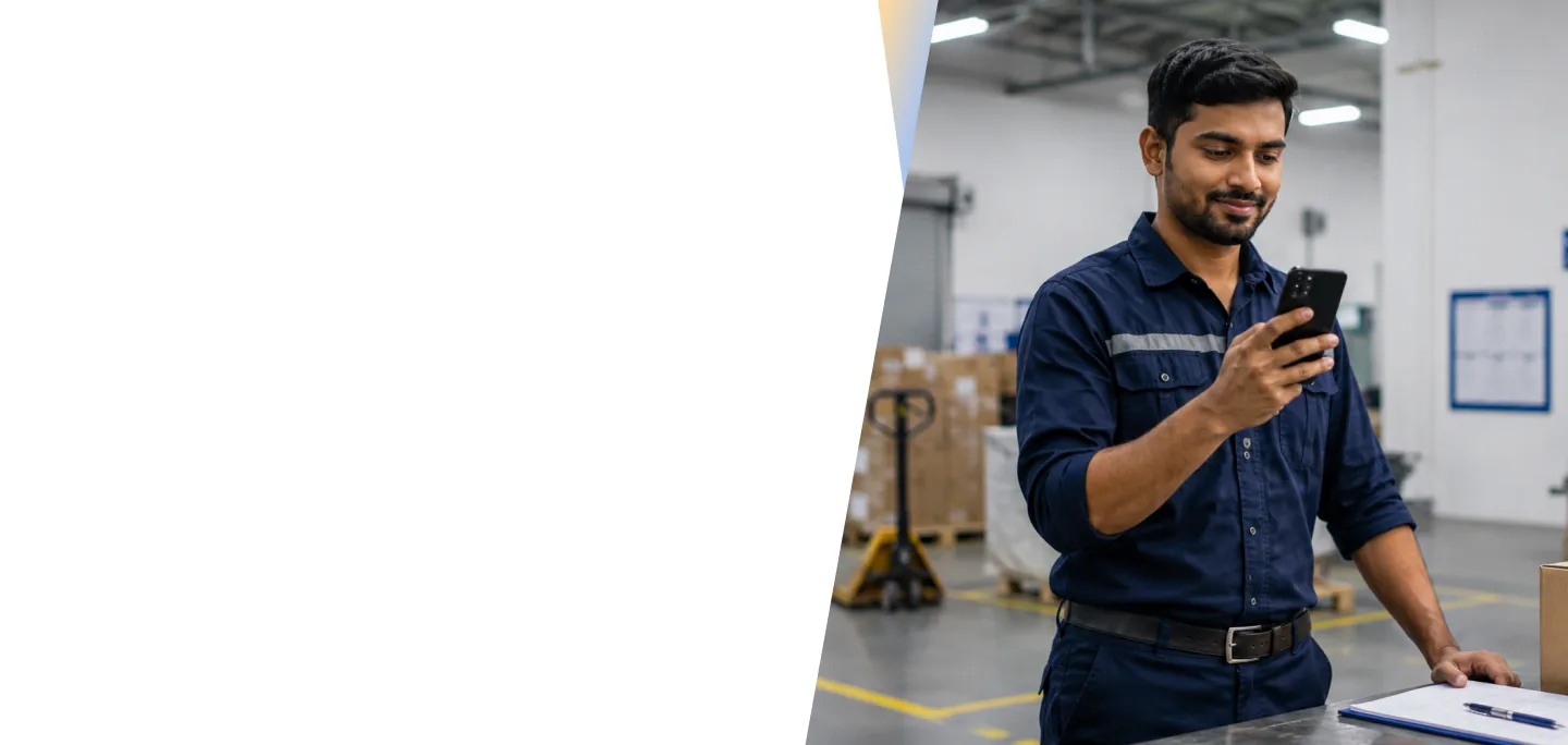 Employee in a warehouse setting using a smartphone to access HR information
