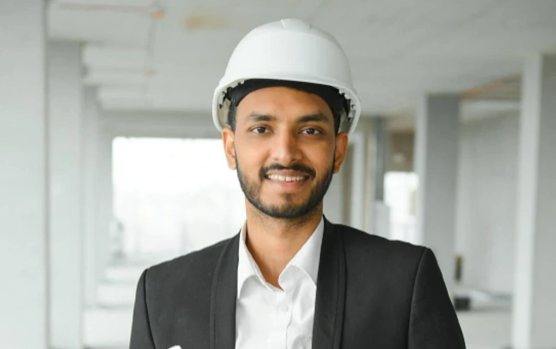 Plant HR leader in a hard hat holding project plans on a construction site