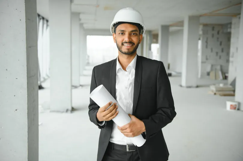 Plant administrator in safety gear reviewing site operations in an industrial facility