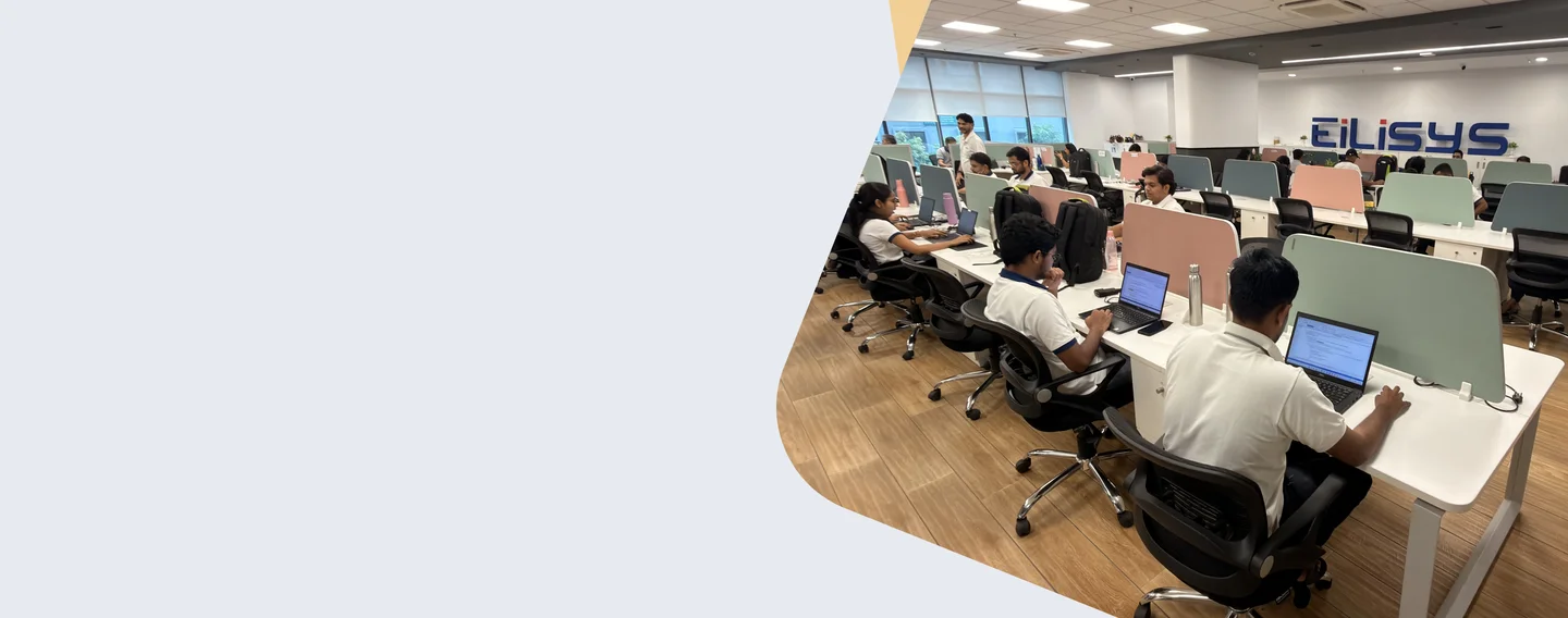 Eilisys team working in a modern open office at long desks with the Eilisys logo on the wall