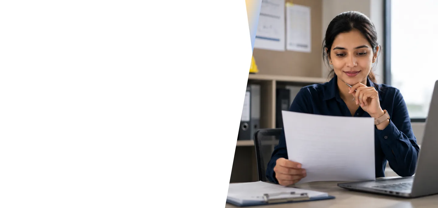 Payroll professional reviewing salary documents at a desk in an office